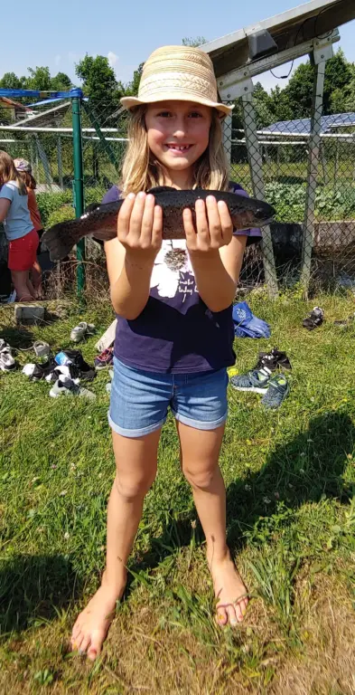 Schule Hugfling Aktuelles Fischweiher Schülerin mit Fisch2b